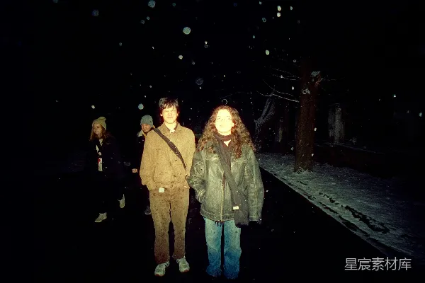 高清摄影 两个人站在夜晚的雪中。