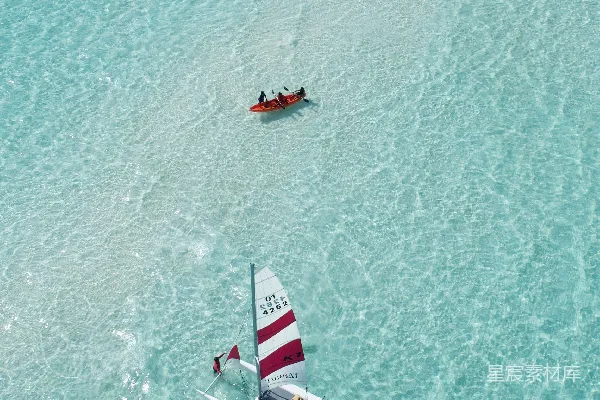 帆船和 kayak 在清澈的天蓝水中