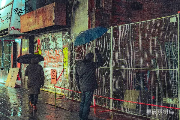 几个人走在街上拿着雨伞