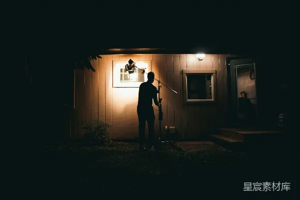 高清摄影 一个男人站在房子外面的夜晚。
