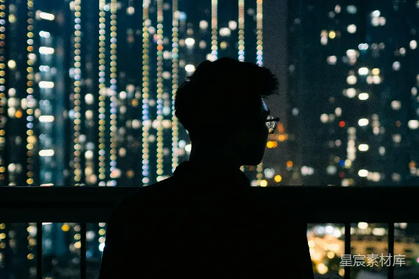 一个男子站在夜晚的窗前