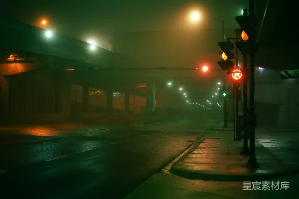 夜晚雾气弥漫的城市街道，交通灯闪烁。