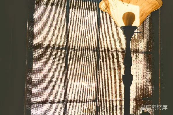 一盏灯置于窗前，阳光透过窗户倾泻而下。