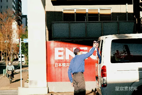 一个男人站在一辆白色货车旁边停车场里