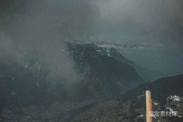 一幅山峦景色图，天空中有云。