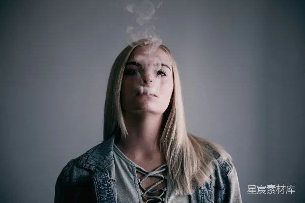 高清摄影 女士穿着灰色上衣，在嘴边吸烟。