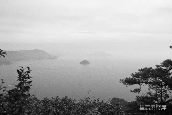 高清摄影 一片水体，周围环绕着树木和山丘。