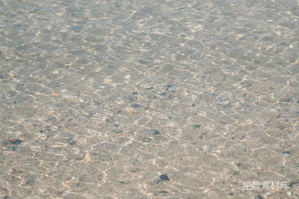 一个站在浅水里拿着冲浪板的人
