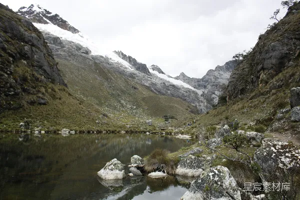 湖中间一片绿草地上方有山峦