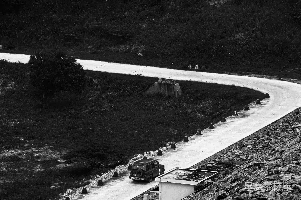 高清摄影 一张黑白照片，一辆卡车正在公路上行驶。