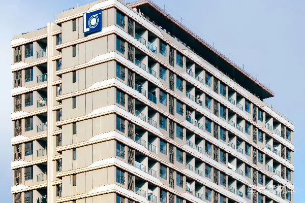 一座现代高层建筑，配有阳台和蓝色logo。