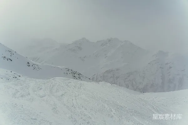 滑雪者站在覆盖着积雪的山坡上