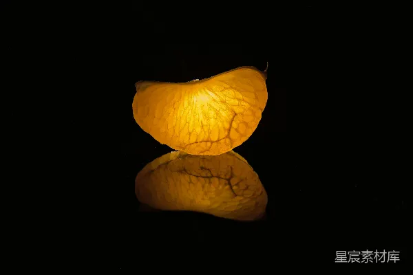 一个橙子放在黑色表面之上