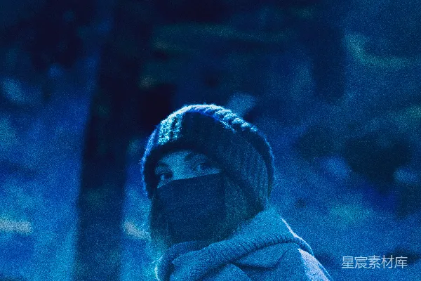 一个戴着口罩的男人站在一棵树前