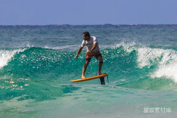 一个男子站在冲浪板上 surfing于波峰之上