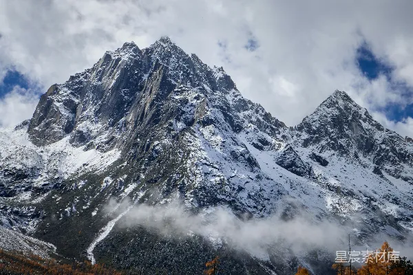 前景中有树木的雪山覆上了一层白雪。