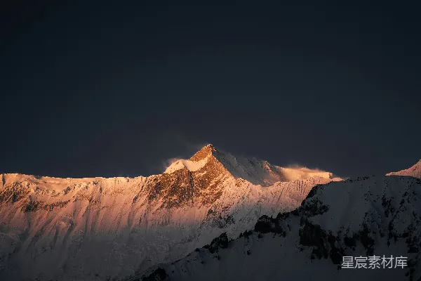 雪山在日落时分闪耀着皑皑白雪的山顶