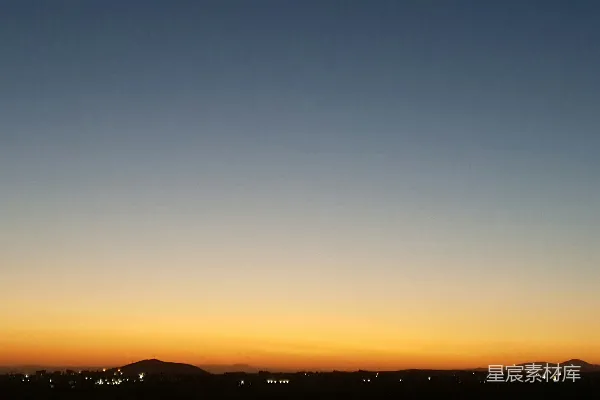 夕阳落下一座城市的背景是山脉。