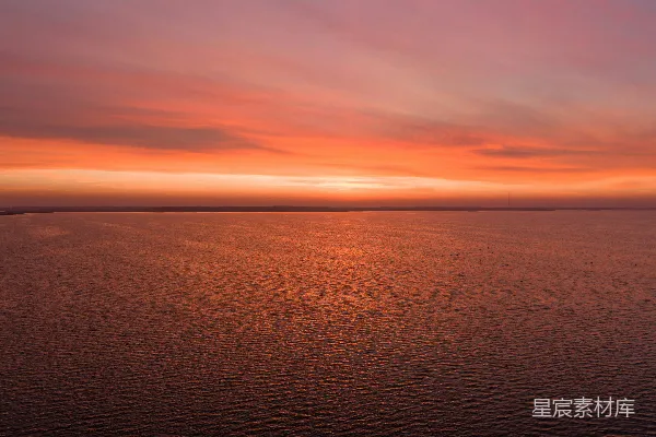 一片绚丽的夕阳映照在平静而闪耀的海洋上。