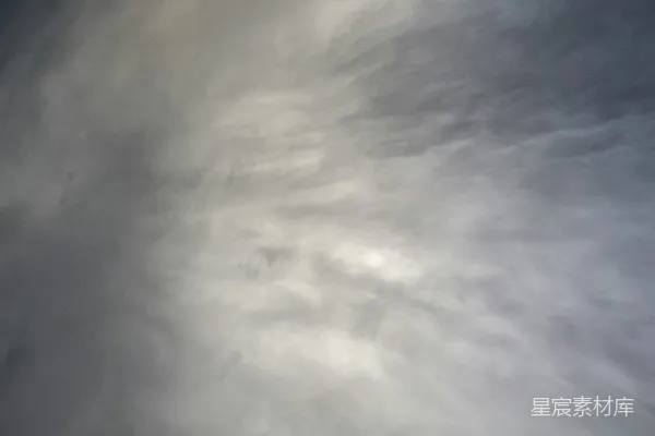 一架飞机穿过一片阴云的蔚蓝天空