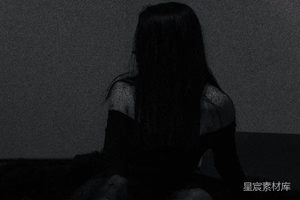 高清摄影 一个女人坐在昏暗房间的地板上。