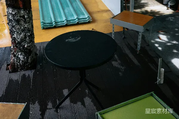 黑色的圆形桌子放在湿滑的木制甲板上。