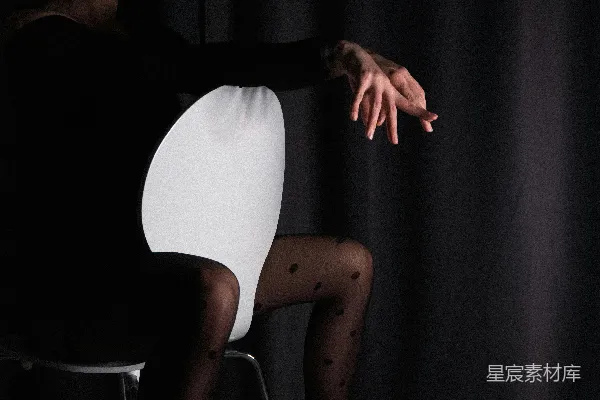 高清摄影 一位穿着黑白相间裙子的女人坐在椅子上