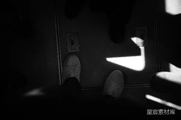 一个站在黑暗中的人，双脚抬起。