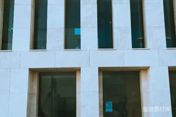 一个女人坐在一栋建筑前的地面上。