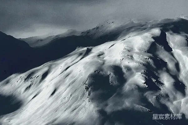 高清摄影 覆盖着积雪的山峰在阴云密布的天空下