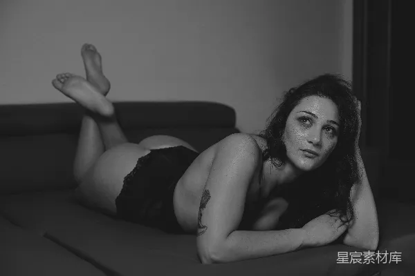 高清摄影 一张黑白照片，照片中一位女士躺在沙发上。