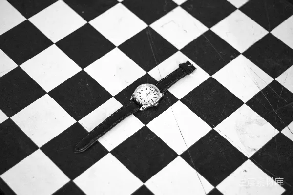银色圆形模拟手表配白色和黑色棋盘格织物