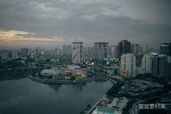 黄昏时分的城市天际线，湖水旁高耸的建筑群。