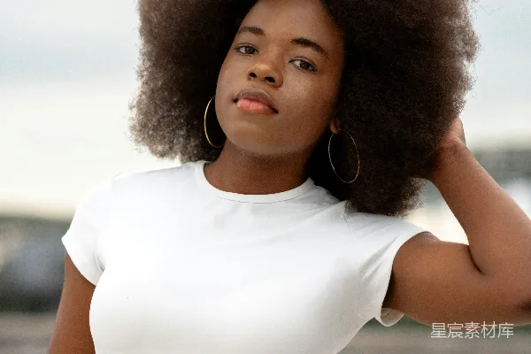一个 Afro 头发的女性正在拍照。