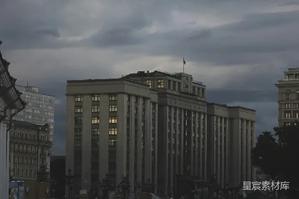 傍晚阴天，人们走过一座大型建筑物旁。