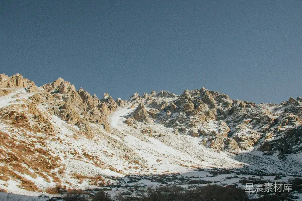 覆盖着白雪的山峦与一片清澈蔚蓝的天空