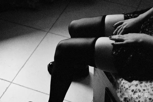 高清摄影 一位女士坐在床上，双腿交叉。