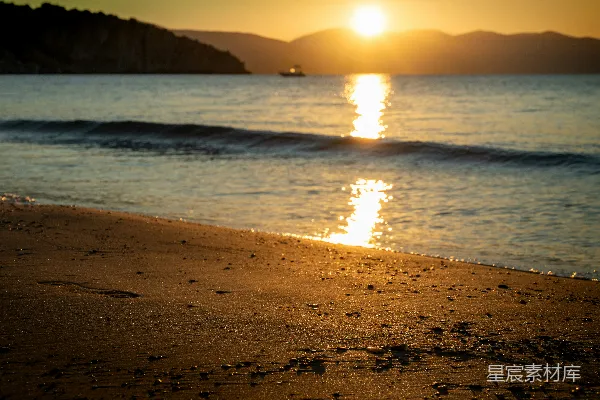 金色夕阳映照平静的海洋，一艘船。