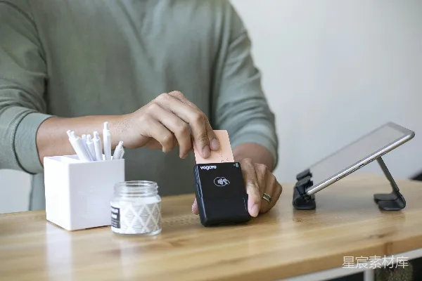 坐在桌子旁的人拿着手机