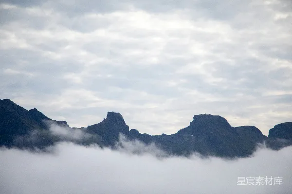 山峰从云层中探出，在一幅风景画里。