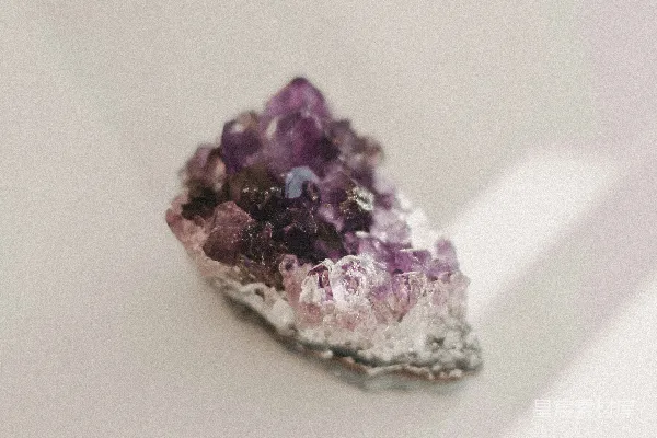 一堆紫色的结晶物摆在白色桌子的顶端