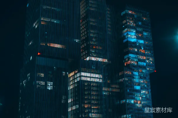 一座非常高大的建筑在夜晚亮起了灯。