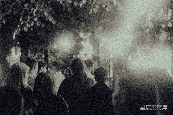 高清摄影 一群人在夜晚沿着街道行走。