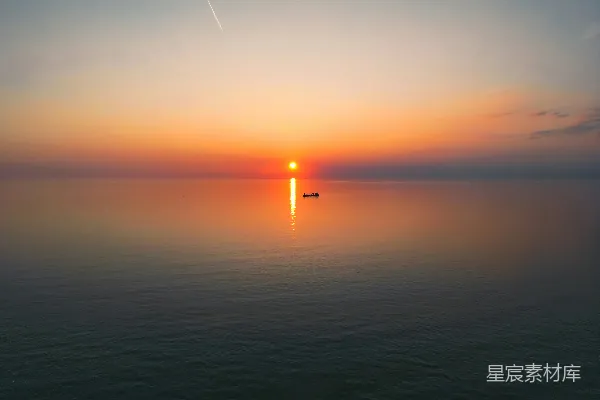 夕阳西下，远处有一艘小船。