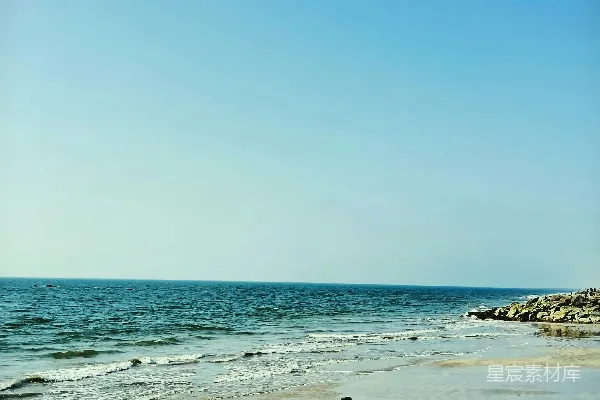 海滩上一个人站在沙地上拿着冲浪板