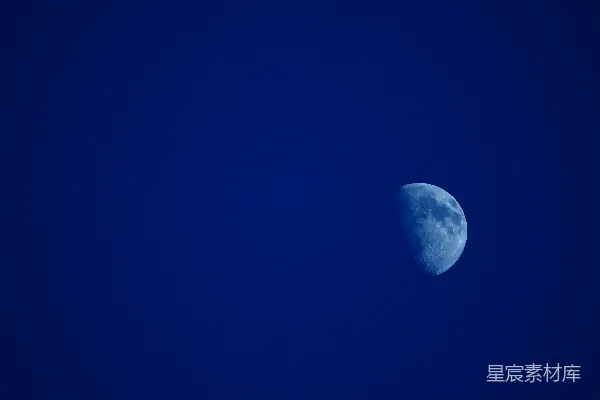 半个月亮在深蓝色的夜空中可见