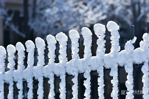 一栋建筑旁边有一道覆盖着白雪的围栏