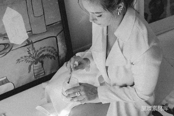 高清摄影 一个女人坐在床上看着手机。