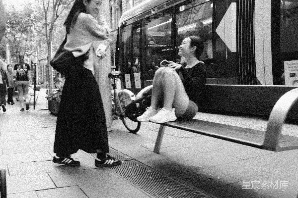高清摄影 一个女人坐在火车旁边的长凳上。