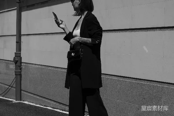 一个女人在街上行走时拿着手机。